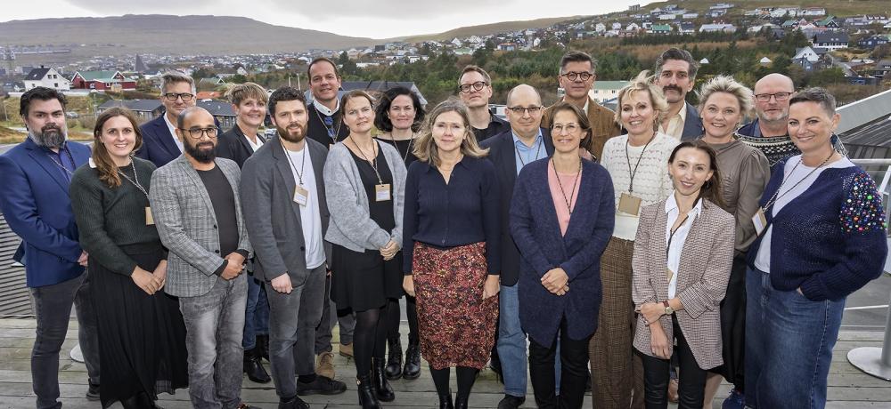 gruppfoto från nordiskt ombudsmannamöte med utsikt från Färöarna i bakgrunden