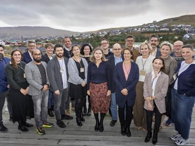 gruppfoto från nordiskt ombudsmannamöte med utsikt från Färöarna i bakgrunden